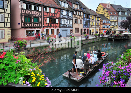 I turisti in barca al viaggio turistico lungo il colorato le case con la struttura in legno alla Petite Venise / Little Venice, Colmar, Francia Foto Stock