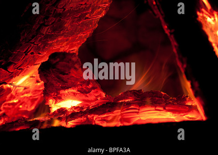 Un close-up di un log fire in una fossa di roccia. Foto Stock