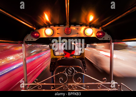 Un Tuk Tuk o auto rickshaw in movimento durante la notte, Bangkok, Thailandia, Sud-est asiatico Foto Stock