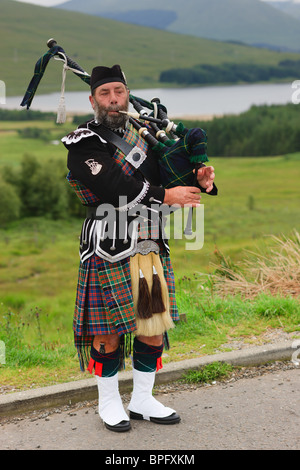 Cornamuse player sulle Highlands scozzesi Foto Stock