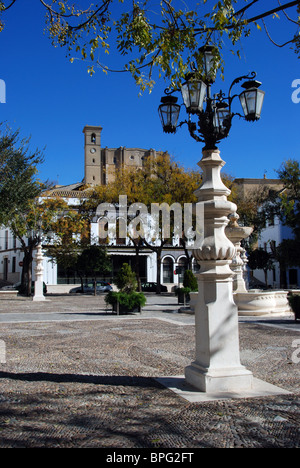 Ornati in ferro battuto lampione in Plaza Mayor con la chiesa per la parte posteriore, Osuna, provincia di Siviglia, in Andalusia, Spagna, Europa. Foto Stock