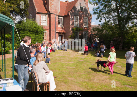 I bambini di competere in carriola gara in un villaggio di fete in Weston , Suffolk , Inghilterra , Gran Bretagna , Regno Unito Foto Stock