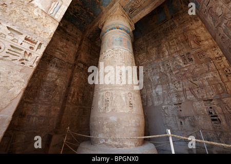 Colonne colorate e il bassorilievo di western colonnato, secondo cortile del tempio mortuario di Ramesse Medinet Habu Luxor Tebe Egitto Foto Stock