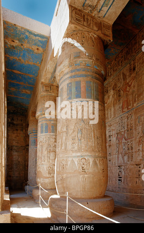 Colonne colorate e il bassorilievo di western colonnato, secondo cortile del tempio mortuario di Ramesse Medinet Habu Luxor Tebe Egitto Foto Stock