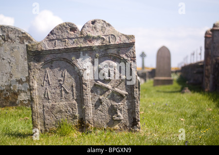 Cranio e crossbones e altri progetti su un edificio del xviii secolo lastra tombale, Scozia Foto Stock