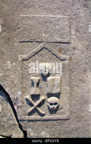 Cranio e crossbones, Clessidra e altri memento mori di progetti su un edificio del xviii secolo graveslab, Scozia Foto Stock