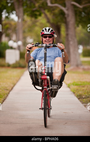 Uomo in sella ad una bicicletta reclinata in un parco Foto Stock