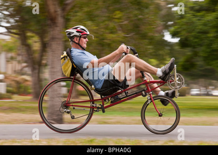 Uomo in sella ad una bicicletta reclinata in un parco Foto Stock