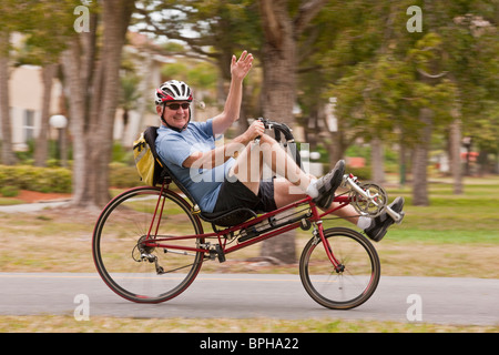 Uomo in sella ad una bicicletta reclinata in un parco Foto Stock