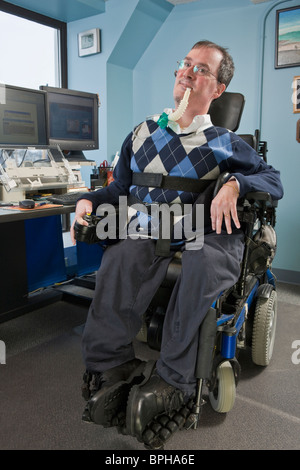 Imprenditore con distrofia muscolare di Duchenne utilizzando un ventilatore di respirazione in un ufficio Foto Stock