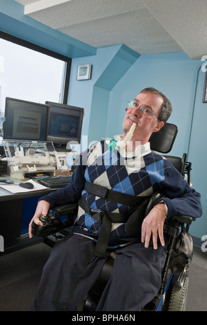 Imprenditore con distrofia muscolare di Duchenne utilizzando un ventilatore di respirazione in un ufficio Foto Stock