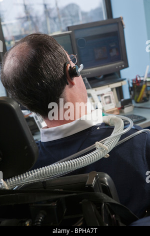 Imprenditore con distrofia muscolare di Duchenne utilizzando un ventilatore di respirazione in un ufficio Foto Stock