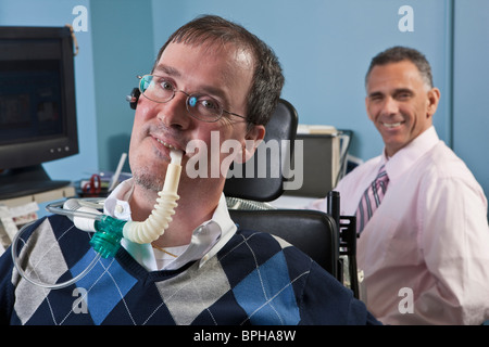 Imprenditore con distrofia muscolare di Duchenne utilizzando un ventilatore per la respirazione e il suo collega con lesioni del midollo spinale dietro di lui Foto Stock