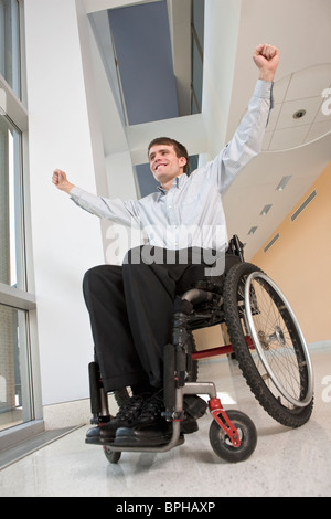 Imprenditore con lesioni al midollo spinale in una sedia a rotelle cercando eccitato Foto Stock