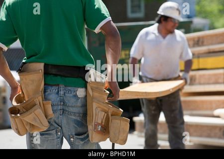 I falegnami di sollevamento di travi lamellari in corrispondenza di un sito in costruzione Foto Stock