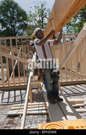 Carpentieri di lavoro in corrispondenza di un sito in costruzione Foto Stock