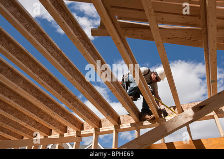 Carpenter lavorando al secondo piano di una casa Foto Stock