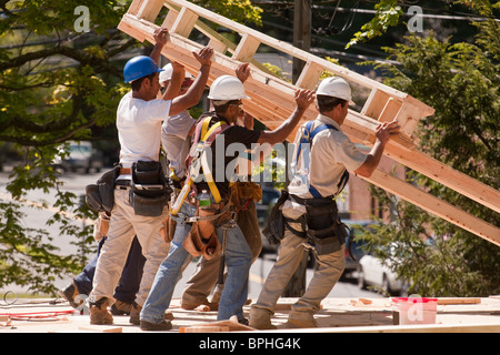 I falegnami di sollevamento timpano di copertura telaio in corrispondenza di un sito in costruzione Foto Stock