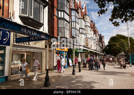 Regno Unito, Inghilterra, Merseyside, Southport, Lord Street, gli acquirenti su un ampio marciapiede nella luce del sole Foto Stock