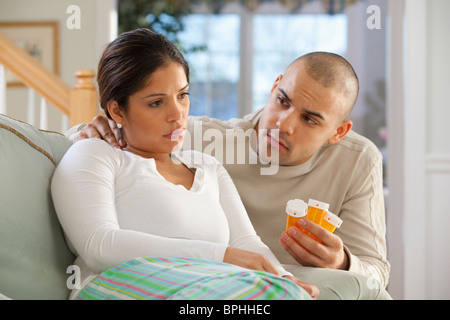 Uomo ispanico dando la medicina a sua moglie Foto Stock