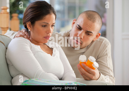 Uomo ispanico dando la medicina a sua moglie Foto Stock