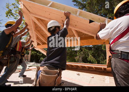 I falegnami di sollevamento timpano di copertura telaio in corrispondenza di un sito in costruzione Foto Stock