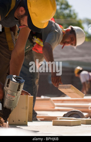 Carpentieri di lavoro con pistola fissachiodi e legno Foto Stock