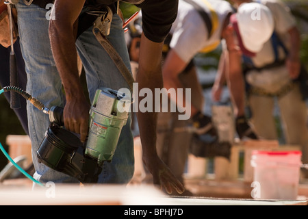 I falegnami di lavorare con le pistole sparachiodi in corrispondenza di un sito in costruzione Foto Stock