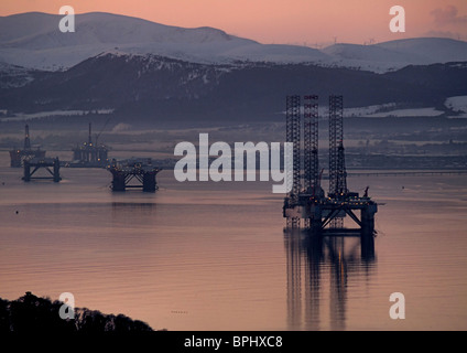 Impianti di trivellazione del petrolio in Cromarty Firth come il sole tramonta in midwinter Foto Stock