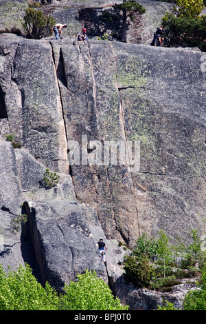 Gli arrampicatori Mouontain sul ripido fianco della montagna di Simonsberget, Tunaberg, Svezia. Foto Stock