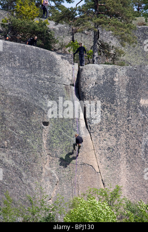 Gli arrampicatori Mouontain sul ripido fianco della montagna di Simonsberget, Tunaberg, Svezia. Foto Stock