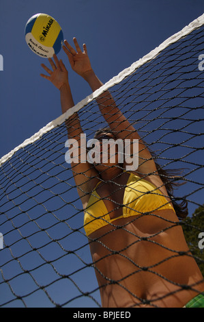 Giovane donna giocando a pallavolo, indossando un bikini giallo, Maiorca, isole Baleari, Spagna Foto Stock
