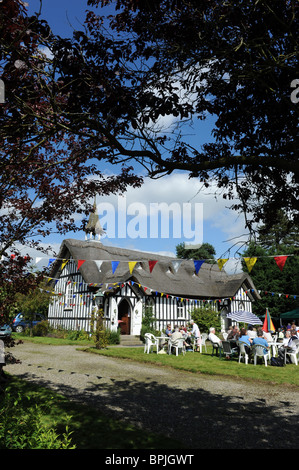 Chiesa di tutti i santi in poco Stretton Shropshire con il tetto di paglia e ospita un giardino inglese partito. Foto Stock