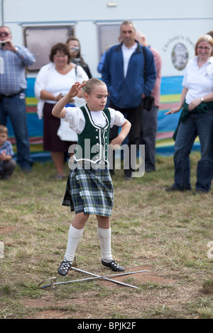 Ragazza giovane danza tra spade collocato sul pavimento. Foto Stock