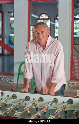 Uomo ispanico giocare a biliardino Foto Stock