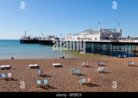 Il Brighton Pier con spiaggia e sdraio su giornata estiva, Brighton, Sussex Foto Stock