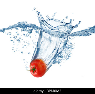 Pomodoro maturo cade profondamente sotto l'acqua con un grande splash. Foto Stock