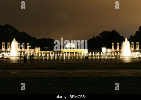 WASHINGTON DC, Stati Uniti: La fontana illuminata del National World War II Memorial sul National Mall di notte. La fontana, una caratteristica centrale del monumento, si riflette splendidamente sull'acqua calma, creando una serena e toccante scena notturna in onore di coloro che hanno prestato servizio nella seconda guerra mondiale Foto Stock