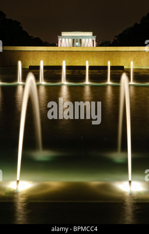National World War II Memorial Fountain Washington DC // WASHINGTON DC - la fontana illuminata del National World War II Memorial mostra di notte sul National Mall. Il memoriale, dedicato nel 2004, onora i 16 milioni di americani che hanno prestato servizio nelle forze armate durante la seconda guerra mondiale e gli oltre 400.000 morti. La fontana è una caratteristica centrale del progetto del memoriale, che comprende 56 pilastri di granito che rappresentano gli stati e i territori degli Stati Uniti durante la guerra. Il monumento si trova tra il Lincoln Memorial e il Washington Monument sul National Mall. Il Lincoln Memor Foto Stock