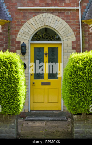 Rivestite con pannelli di legno in stile vittoriano e vetrate dipinte di giallo porta anteriore di mattoni casa costruita in Llandrindod Wells Powys Mid Wales UK Foto Stock