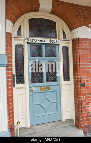 Victorian rivestite con pannelli di legno dipinto di blu porta anteriore con vetro macchiato di mattoni costruito casa a Llandrindod Wells Powys Mid Wales UK Foto Stock