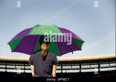 Una ragazza a sfera detiene un ombrello sulla corte 1 durante il torneo di Wimbledon Tennis Championships 2010 Foto Stock