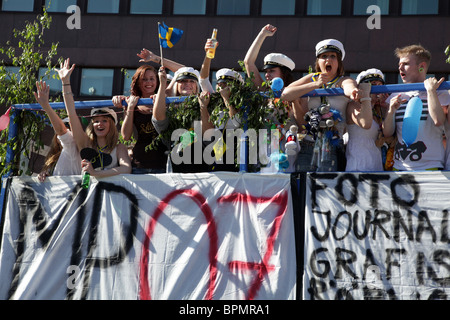 È una tradizione divertente e folle: Gli studenti universitari svedesi celebrano il giorno della laurea su un autobus scoperto nel centro di Stoccolma in Svezia Foto Stock