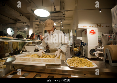 Un lavoratore prepara fresca pasta fatta sul display a Michelis a Eataly marketplace italiani a New York Foto Stock
