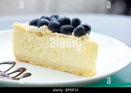 Una fetta di cheesecake al forno con mirtilli freschi sulla parte superiore Foto Stock