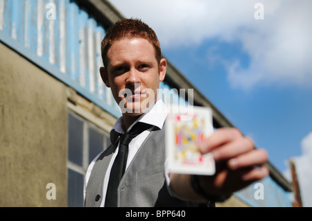 I giovani maschi bianco Mago di eseguire trucchi di carta al di fuori Foto Stock