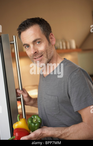 Uomo in piedi di fronte frigo Foto Stock
