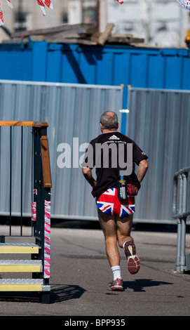Un pareggiatore indossando unione jack shorts in esecuzione in Southend on Sea in Essex. Foto Stock