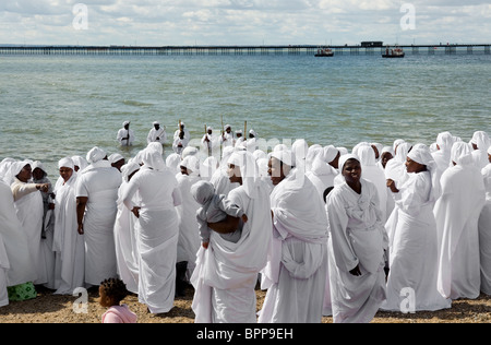 I membri degli apostoli della Chiesa Muchinjikwa effettuando un battesimo nell'estuario del Tamigi a Southend. Foto Stock