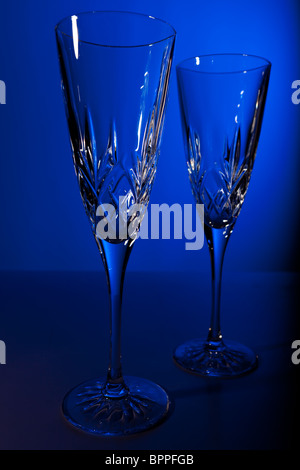 Studio shot di due crystal champagne flauti contro uno sfondo blu Foto Stock